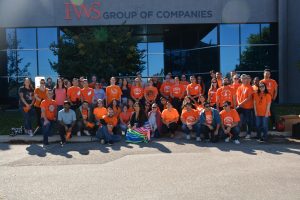 FWS employees posing in front of FWS Winnipeg office wearing orange shirts